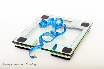 Weight loss. Measurement tape on weigh scale. 